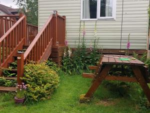 a wooden bench in a yard next to a house at Hills View Accommadation in Borrisoleigh
