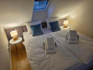 a bedroom with a large white bed with two lamps at Apartamenty Kukinia33 in Kukinia