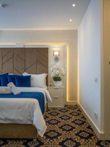 a bedroom with a large bed with blue and white pillows at Hotel Belvedere in Eforie Nord