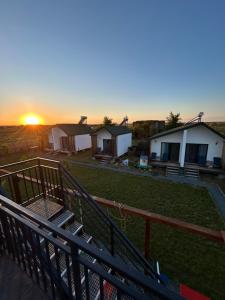 a view of a group of huts with the sunset in the background at Summer Home Corbu in Corbu