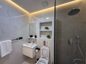 a bathroom with a white toilet and a sink at LA VILLA Appart in Al Hoceïma