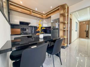 a kitchen with a black counter and some chairs at LA VILLA Appart in Al Hoceïma +38 photos