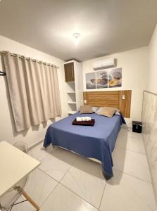 a bedroom with a bed with a blue blanket at Cantinho Aconchegante - Apartamento Completo in Bayeux