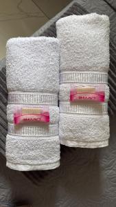 four towels stacked on top of each other at Cantinho Aconchegante - Apartamento Completo in Bayeux