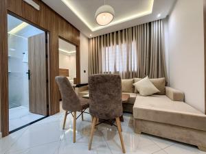 a living room with a couch and a table and chairs at LA VILLA Appart in Al Hoceïma