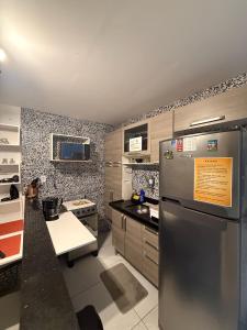 a kitchen with a stainless steel refrigerator and a counter at Cantinho Aconchegante - Apartamento Completo in Bayeux