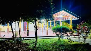 a building with a pavilion in a park with trees at Samadi hotel and resort in Kekirawa