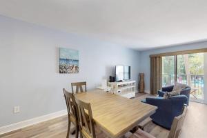 a living room with a wooden table and chairs at Xanadu D8 in Hilton Head Island