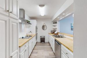 a kitchen with white cabinets and wooden counter tops at Xanadu D8 in Hilton Head Island +20 photos