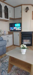 a living room with a table and a tv at Hills View Accommadation in Borrisoleigh +13 photos