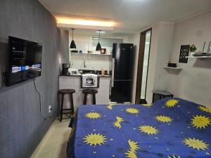 a bedroom with a bed with a blue blanket with yellow stars at Suite aconchegante e Charmosa - centro de Teresópolis in Teresópolis