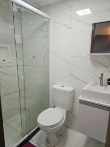 a bathroom with a toilet and a glass shower at Suite aconchegante e Charmosa - centro de Teresópolis in Teresópolis