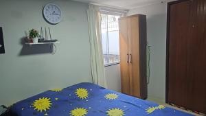 a bedroom with a bed and a clock on the wall at Suite aconchegante e Charmosa - centro de Teresópolis in Teresópolis