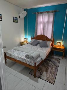 a bedroom with a bed with a wooden frame and a window at Gloria's Hideaway in Christ Church