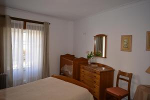 - une chambre avec un lit, une commode et un miroir dans l'établissement Apartamento T1 Ericeira, à Ericeira