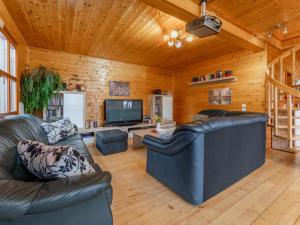 a living room with two leather couches and a tv at Sternenchalet in Liebenfels