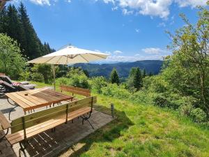 a picnic table with an umbrella and a view of the mountains at Sternenchalet in Liebenfels