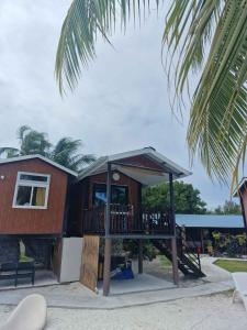 a house with a deck on the beach at Takava Lodge in Fakarava