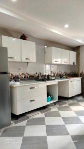 a large kitchen with white cabinets and a checkered floor at Anis in Annaba