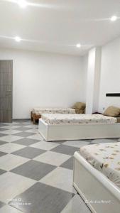 two beds in a room with a checkered floor at Anis in Annaba