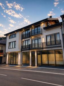 a large white building with a balcony on a street at Vi Lux Apartments in Visoko