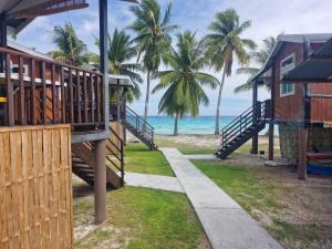 a walkway leading to a beach with palm trees at Takava Lodge in Fakarava