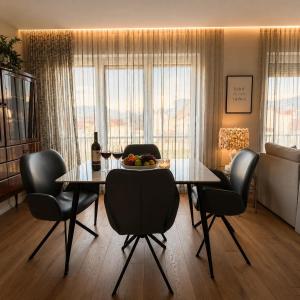 a dining table and chairs in a living room at Vi Lux Apartments in Visoko