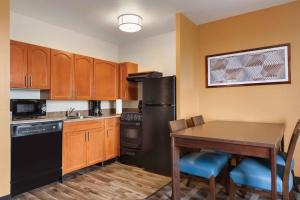 a kitchen with a table and a black refrigerator at Extended Stay America Suites - Denver - Broomfield in Broomfield