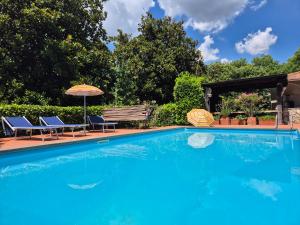 a swimming pool with two chairs and an umbrella at WIKI HOSTEL Colive - Adults Only & Pet Friendly in Zagarolo