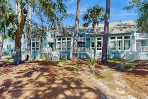 a blue house with palm trees in front of it at Egrets Pointe 491 in Edisto Beach
