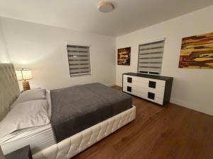 a white bedroom with a bed and a night stand at Casa relax in North Miami Beach