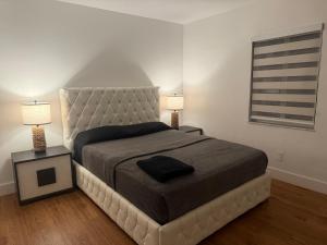 a bedroom with a large bed with two lamps at Casa relax in North Miami Beach
