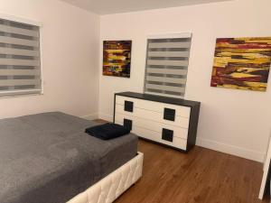 a bedroom with a bed and a dresser and paintings at Casa relax in North Miami Beach