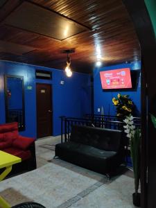a living room with a couch and a blue wall at Hospedaje Mundial in Villeta