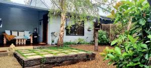 a garden in front of a blue house at Brushwood Studio - Eco Hideaway - Denmark WA in Denmark