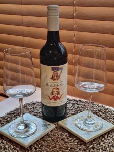 a bottle of wine and two glasses on a table at Brushwood Studio - Eco Hideaway - Denmark WA in Denmark +19 photos