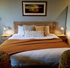 a large bed in a bedroom with two lamps at Brushwood Studio - Eco Hideaway - Denmark WA in Denmark