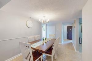 a dining room with a table and a clock on the wall at Beach Club Bungalow in Hilton Head Island