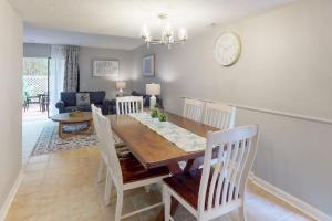 a dining room and living room with a table and chairs at Beach Club Bungalow in Hilton Head Island