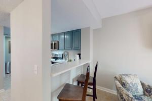 a kitchen with blue cabinets and a table and a chair at Beach Club Bungalow in Hilton Head Island