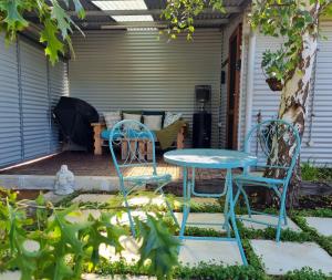 a patio with two chairs and a table and a bench at Brushwood Studio - Eco Hideaway - Denmark WA in Denmark