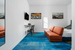 ein Zimmer mit einer Couch, einem Bett und einem Schreibtisch in der Unterkunft Plush Hotel Downtown Toronto in Toronto