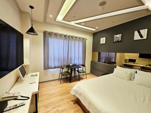 a bedroom with a bed and a desk and a table at If Business Hotel in Changwon