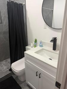 a bathroom with a toilet and a sink and a mirror at Casa paz in North Miami Beach