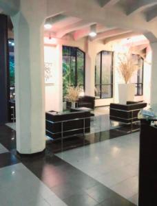 a large lobby with black furniture and windows at Departamento al Canal in Buenos Aires