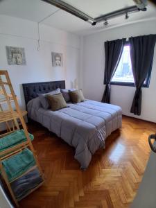 a large bed in a room with a ladder at Departamento al Canal in Buenos Aires +3 photos