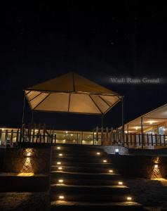 a building with a tent and stairs at night at WADI RuM GRAND in Wadi Rum