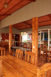 a dining room with a table and wooden chairs at Pousada Recanto dos Buritis in Manhã