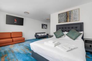 ein Schlafzimmer mit einem großen weißen Bett und einer Couch in der Unterkunft Plush Hotel Downtown Toronto in Toronto + 33 Fotos