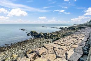 a rocky shoreline with rocks and the water at Sunrise Waterfront Retreat in Milford +42 photos